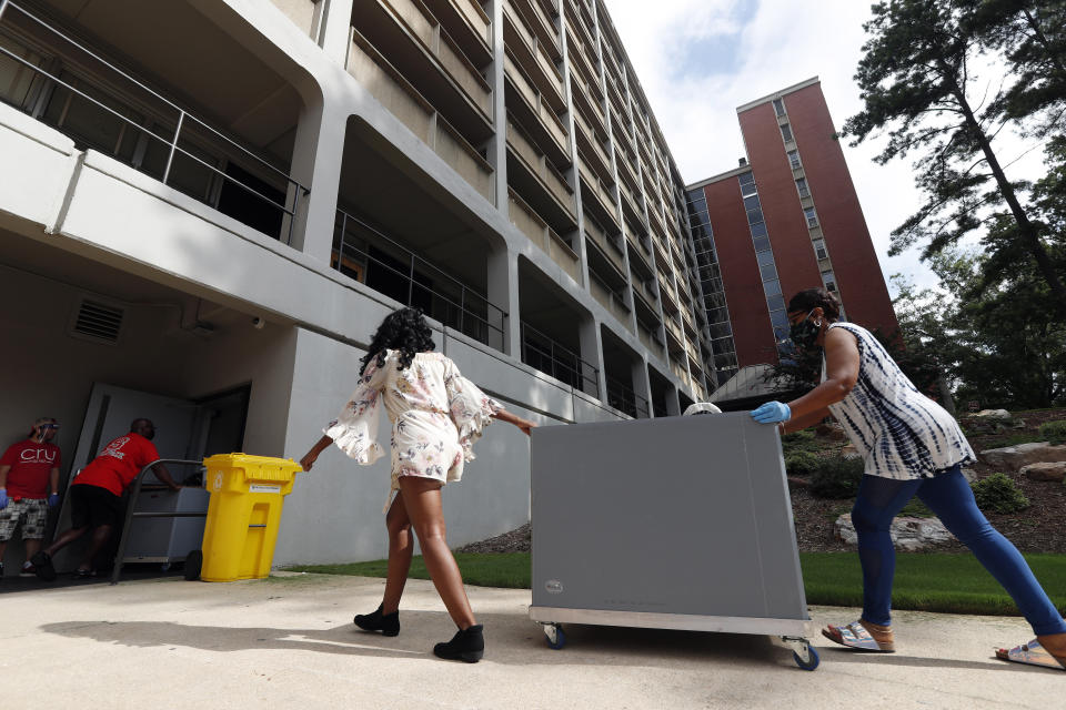 College students begin moving in for the fall semester at N.C. State University in Raleigh, N.C., Friday, July 31, 2020. The first wave of college students returning to their dorms aren’t finding the typical mobs of students and parents. At N.C. State, the return of students was staggered over 10 days and students were greeted Friday by socially distant volunteers donning masks and face shields. . (AP Photo/Gerry Broome)