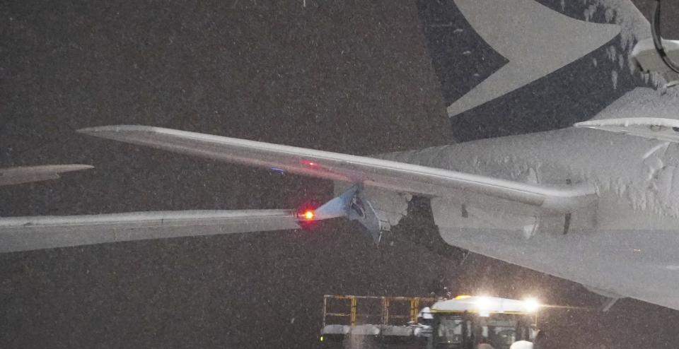 A part of wing of a Korean Air plane, left, and Cathay Pacific aircraft, right, are seen after a collision at northern Japan's New Chitose Airport in Sapporo, Tuesday, Jan. 16, 2024. A Korean Air plane carrying 289 people hit a parked Cathay Pacific aircraft while being pushed by a ground vehicle ahead of takeoff at northern Japan's New Chitose Airport on Tuesday but caused no fire or injuries, fire and airline officials said. (Kyodo News via AP)