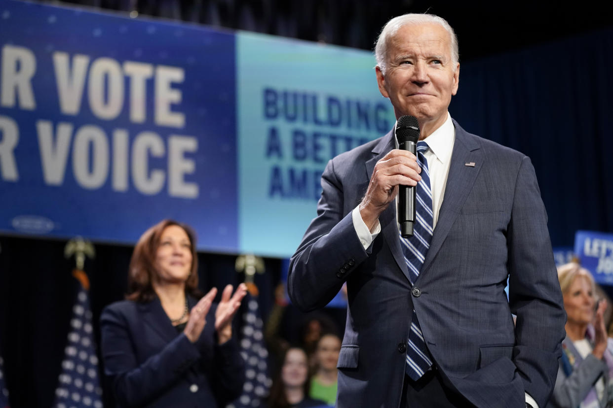 Vice President Kamala Harris applauds as President Biden speaks.