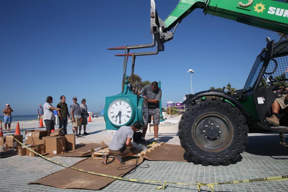 Crews with the Verdin Company and Kell]y General Contracting install the new clock in Times Square on Fort Myers Beach on Thursday, Sept. 14, 2023. The original clock was destroyed after Hurricane Ian decimated the island on Sept. 28, 2022 . The clock will be covered until it is unveiled during a ceremony on Sept. 28, 2023.