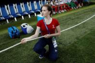 A volunteer holds a rope to prevent photographers entering the bench area before the 2018 FIFA World Cup soccer match between Switzerland and Costa Rica at Nizhny Novgorod Stadium in Nizhny Novgorod, Russia June 27, 2018. REUTERS/Murad Sezer