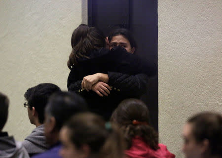 People hug during a mass at a local church after a teenage student shot several students and a teacher at the private school Colegio Americano del Noreste before killing himself, in Monterrey, Mexico, January 18, 2017. REUTERS/Daniel Becerril