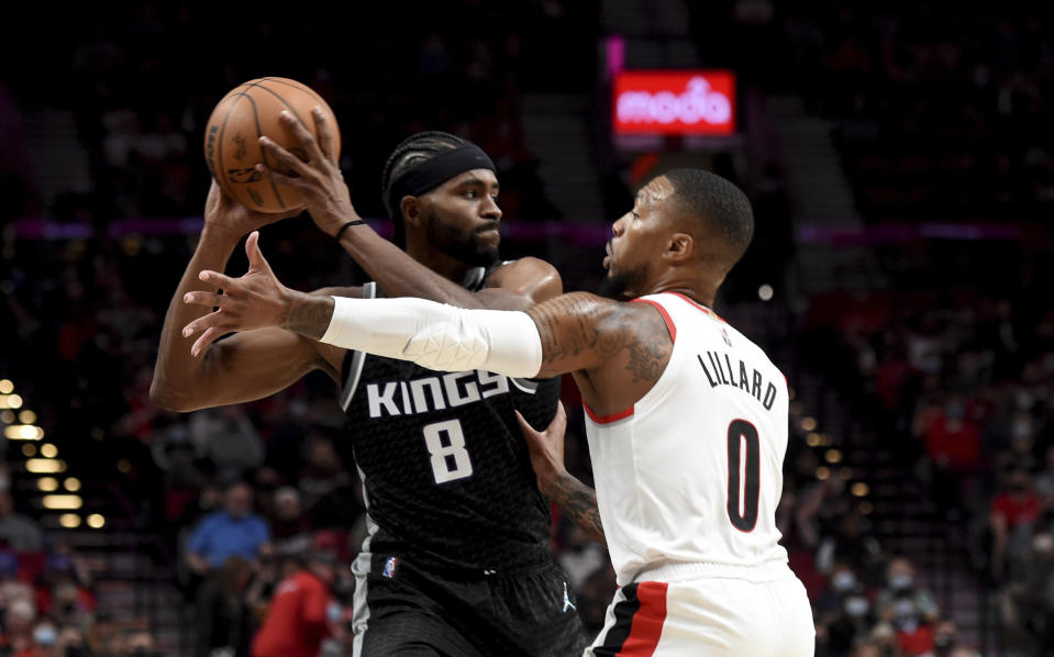 Sacramento Kings forward Maurice Harkless, left, looks to pass the ball as Portland Trail Blazers guard Damian Lillard defends during the first half of an NBA basketball game in Portland, Ore., Wednesday, Oct. 20, 2021. (AP Photo/Steve Dykes)