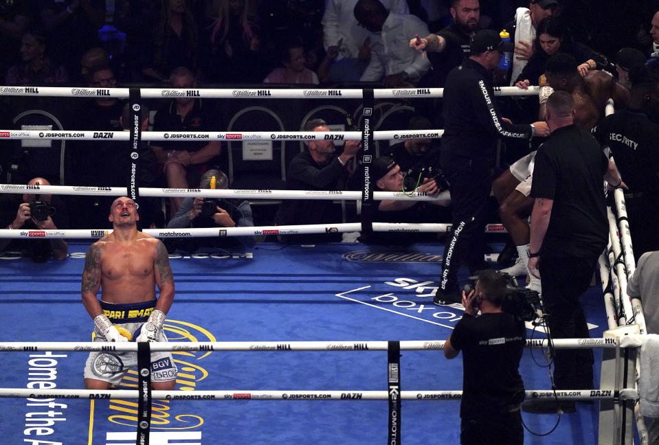 Oleksandr Usyk, left, of Ukraine celebrates after winning the WBA (Super), WBO and IBF boxing title bout against Anthony Joshua, right, of Britain at the Tottenham Hotspur Stadium in London Saturday Sept. 25, 2021. (Nick Potts/PA via AP)