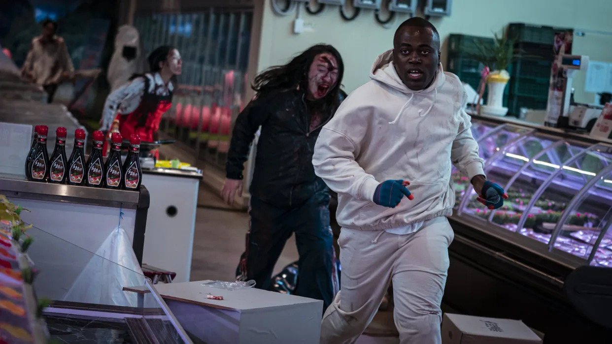  A contestant runs from some zombies in Netflix's Zombiverse reality TV show 