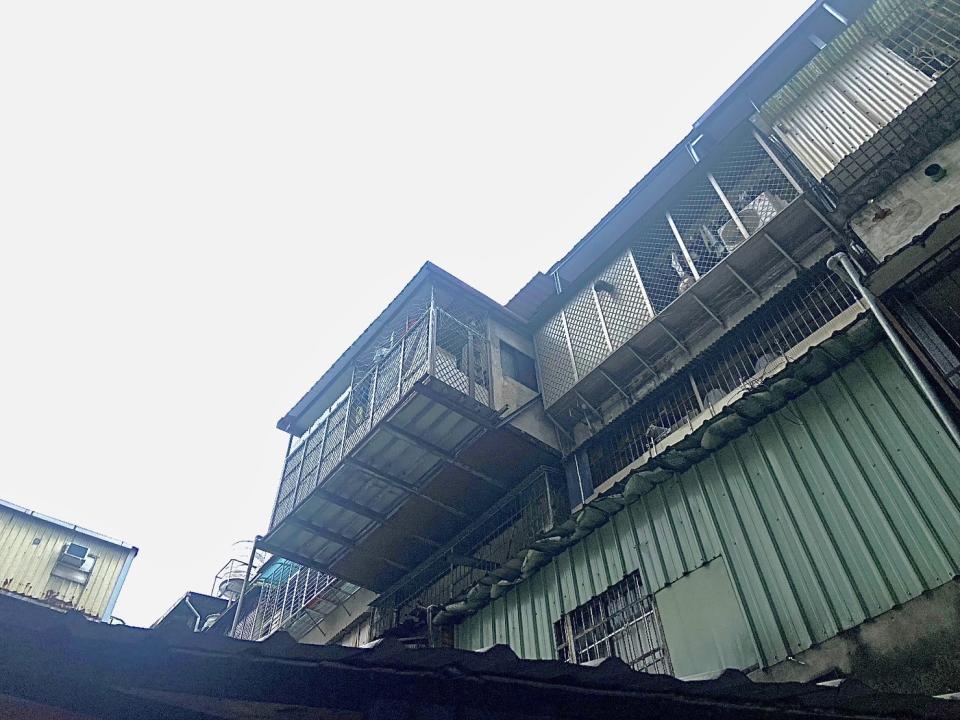 新莊區西盛街一處老舊公寓，外推違建懸掛空中有安全之虞。   圖：新北市工務局提供