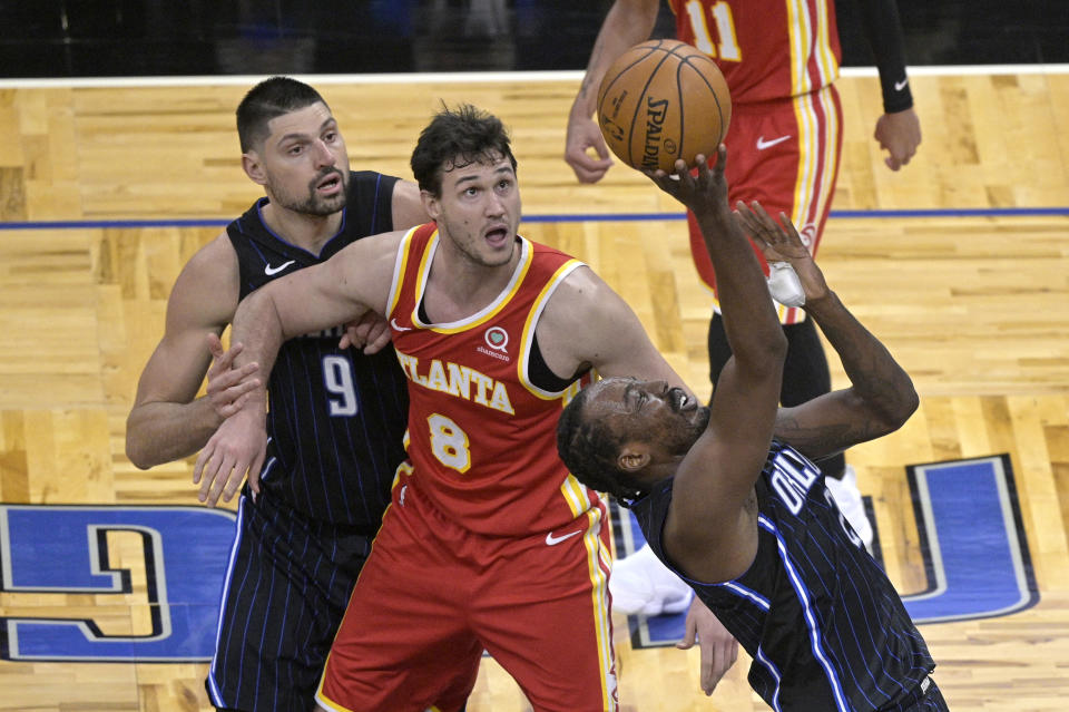 Orlando Magic forward Al-Farouq Aminu (2) shoots in front of center Nikola Vucevic (9) and Atlanta Hawks forward Danilo Gallinari (8) during the second half of an NBA basketball game Wednesday, March 3, 2021, in Orlando, Fla. (AP Photo/Phelan M. Ebenhack)