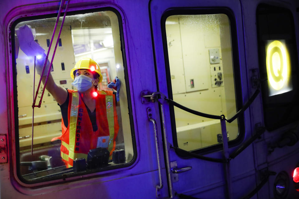 A contractor cleans a subway car at the 96th Street station to control the spread of COVID-19, Thursday, July 2, 2020, in New York. Mass transit systems around the world have taken unprecedented — and expensive — steps to curb the spread of the coronavirus, including shutting down New York subways overnight and testing powerful ultraviolet lamps to disinfect seats, poles and floors. (AP Photo/John Minchillo)