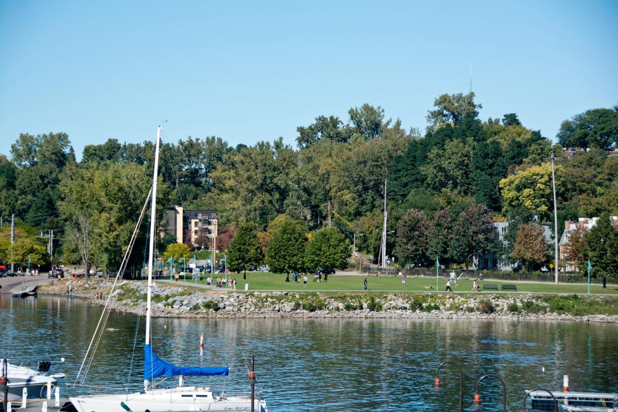 walkers throng the island line trail while others relax and play sports at waterfront park on a sunny autumn afternoon