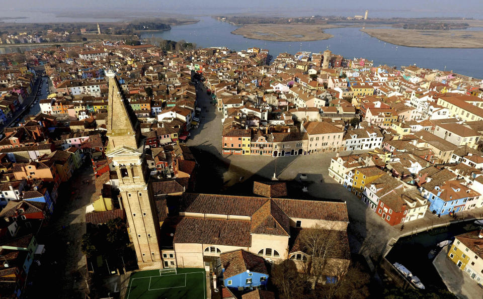 This image taken on Thursday, Jan. 16, 2020, shows an overview of the Burano island, Italy. The Venetian island of Burano's legacy as a fishing village remains the source of its charms: the small colorful fishermen's cottages, traditional butter cookies that were the fishermen's sustenance at sea and delicate lace still stitched by women in their homes. As the island's population dwindles, echoing that of Venice itself, so too are the numbers of skilled artisans and tradespeople who have kept the traditions and economy alive. (AP Photo/Luca Bruno)