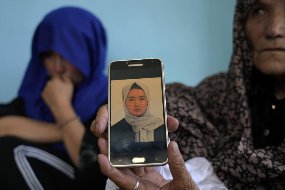 An Afghan woman shows a picture o fa 19-years old girl who was victim of a suicide bomber, in Kabul, Afghanistan, Friday, Sept. 30, 2022. A Taliban spokesman says a suicide bomber has killed several people and wounded others at an education center in a Shiite area of the Afghan capital. The bomber hit while hundreds of teenage students inside were taking practice entrance exams for university, a witness says. (AP Photo/Ebrahim Noroozi)