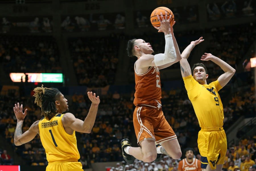 Texas guard Chendall Weaver (2) is defended by West Virginia guard Noah Farrakhan (1) and forward Ofri Naveh (9) during the first half of an NCAA college basketball game on Saturday, Jan. 13, 2024, in Morgantown, W.Va. (AP Photo/Kathleen Batten)