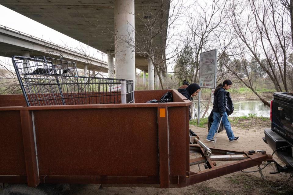 Volunteers pick up trash as part of the Operation 9-2-99 river cleanup along the Tuolumne River in Modesto, Calif., Saturday, March 9, 2024.