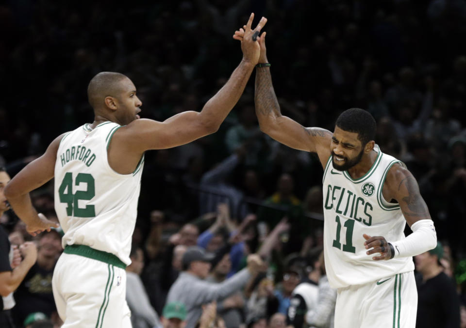 Boston Celtics guard Kyrie Irving (11) and center Al Horford (42) celebrate after scoring during the overtime period of an NBA basketball game against the Toronto Raptors, Friday, Nov. 16, 2018, in Boston. The Celtics won 123-116 in overtime. (AP Photo/Elise Amendola)