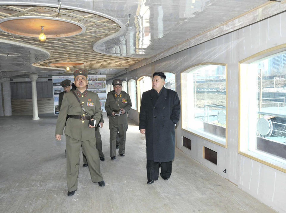 This picture released by North Korea's official Korean Central News Agency on March 26, 2013 and taken on March 25, 2013 shows North Korean leader Kim Jong-Un (C) speaking with officials  during his inspection of the landing and anti-landing drills of KPA Large Combined Units 324 and 287 and KPA Navy Combined Unit 597 at an undisclosed location on North Korea's east coast.