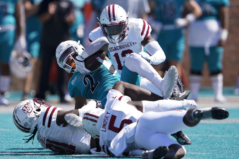 Coastal Carolina running back Reese White is tackled by Massachusetts during the first half of an NCAA college football game on Saturday, Sept. 25, 2021, in Conway, S.C. (AP Photo/Chris Carlson)