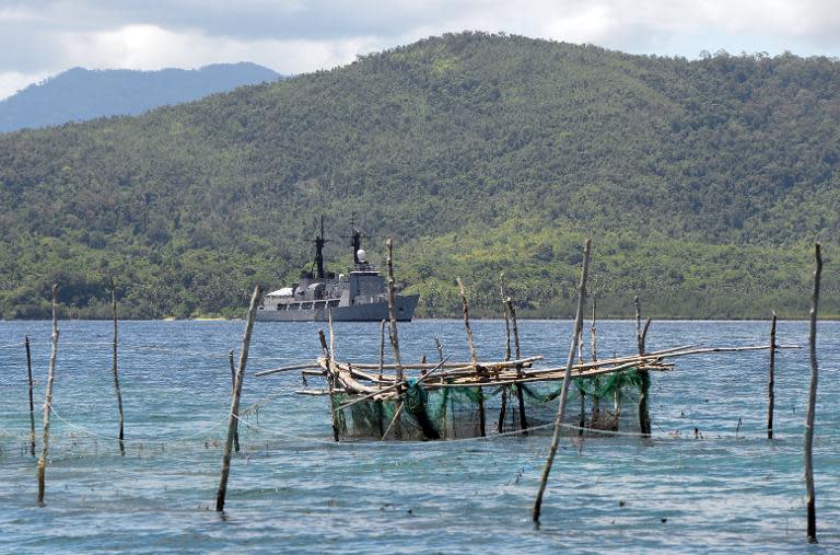 A file photo shows Philippine Navy frigate (in background) at the mouth of the South China Sea off Palawan island, June 7, 2014