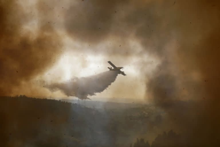 Un avión contra incendios descarga sobre un incendio forestal en la aldea de Casal da Quinta, afueras de Leiria, Portugal, 12 de julio de 2022. (AP Foto/Joao Henriques)