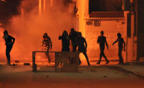 <p>Tunisian protestors throw stones towards security forces in Tunis’ Djebel Lahmer district early on Jan.10, 2018 after price hikes ignited protests in the North African country. (Photo: Sofiene Hamdaoui/AFP/Getty Images) </p>