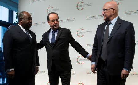 French President Francois Hollande (C) and French Finance Minister Michel Sapin (R) greet Gabon's President Ali Bongo as he arrives to attend the Franco-African Forum at the Bercy Finance Ministry in Paris, February 6, 2015. REUTERS/Ian Langsdon/Pool/File Photo