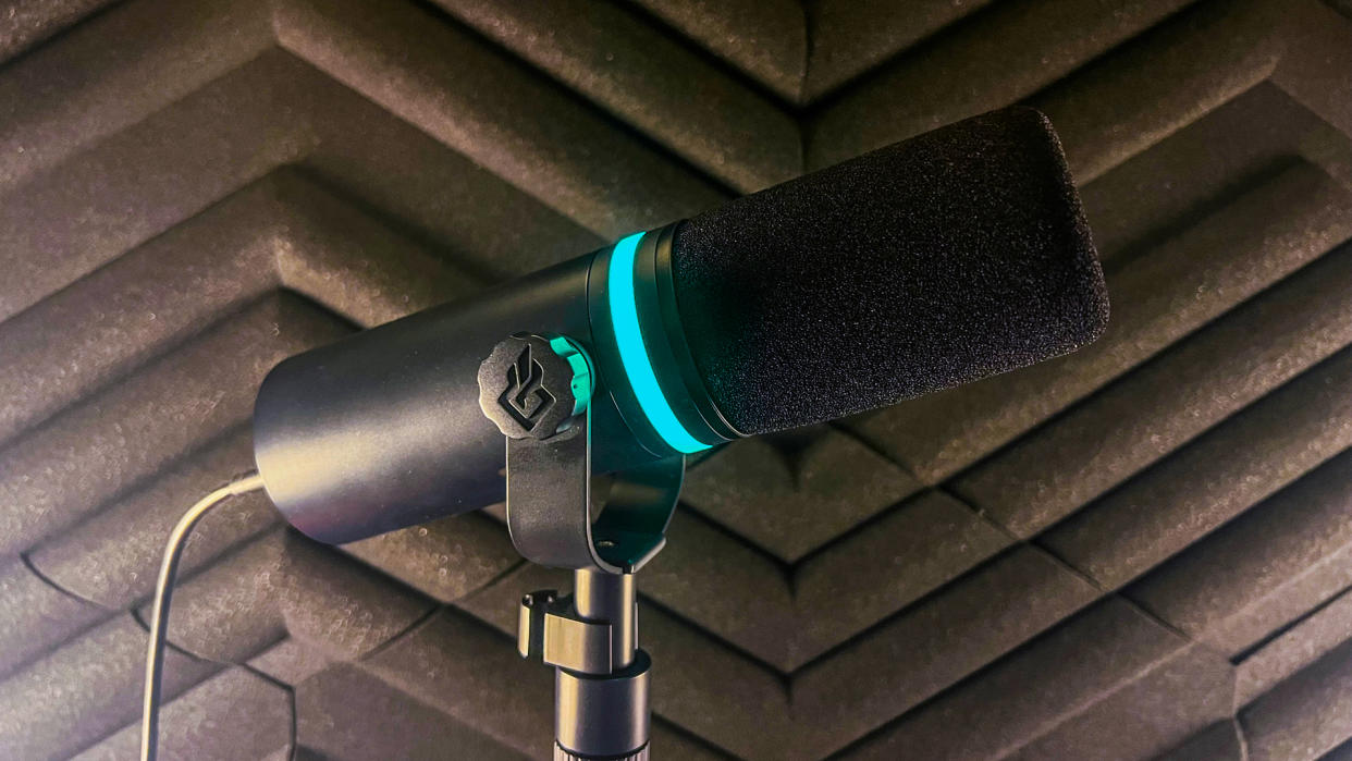  BEACN Mic pictured from the side in front of a soundproof wall panel - the RGB light is blue. 