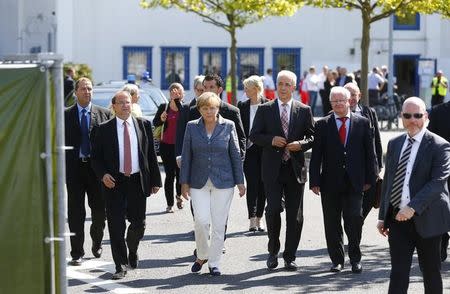 Heidenau major Juergen Opitz, German Chancellor Angela Merkel, Saxony State Prime Minister Stanislaw Tillich and President of the German Red Cross Rudolf Seiters (2ndL to R) arrive for statements after their visit to an asylum seekers accomodation facility in the eastern German town of Heidenau near Dresden, August 26, 2015 where last week more than 30 police were injured in clashes, when a mob of several hundred people pelted officers with bottles and fireworks. REUTERS/Axel Schmidt