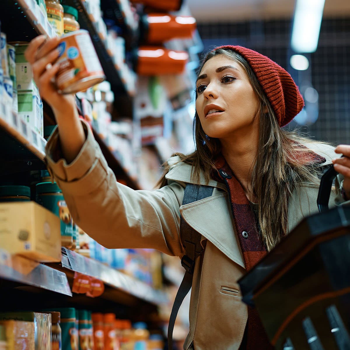 woman buying canned good at grocery store