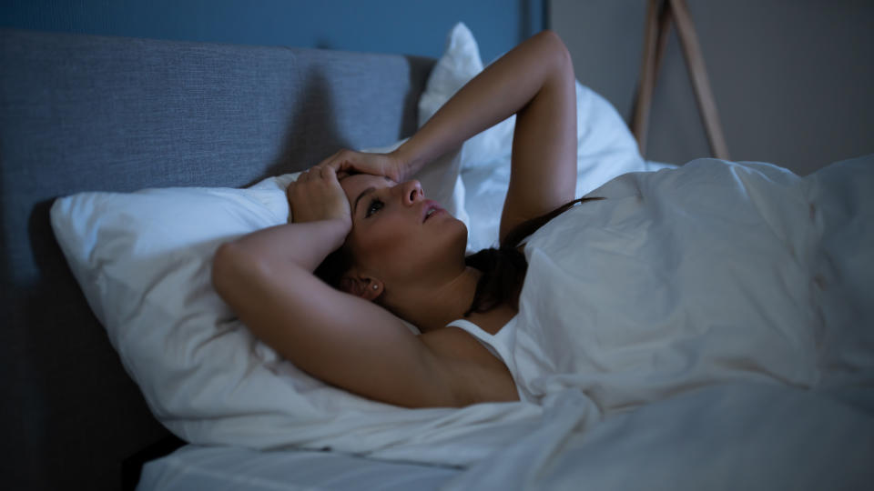 A woman lies awake in bed at night after having a nightmare