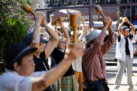 Elderly and middle-aged people exercise with wooden dumbbells during a health promotion event to mark Japan's "Respect for the Aged Day" at a temple in Tokyo's Sugamo district, an area popular among the Japanese elderly, Japan, September 18, 2017. REUTERS/Toru Hanai