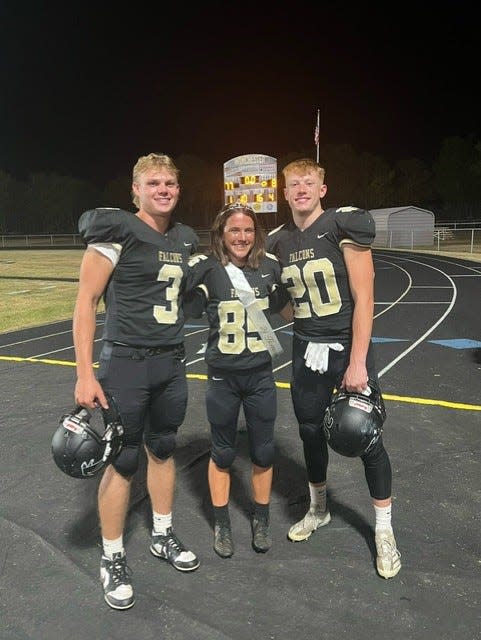 Winchester Falcons kicker Aubrey Weigand (No. 85) with holder Nate Winkle (No. 3) and long snapper Caleb Hummel (No. 20) after breaking Winchester's single-game PATs record and being crowned homecoming queen at halftime.