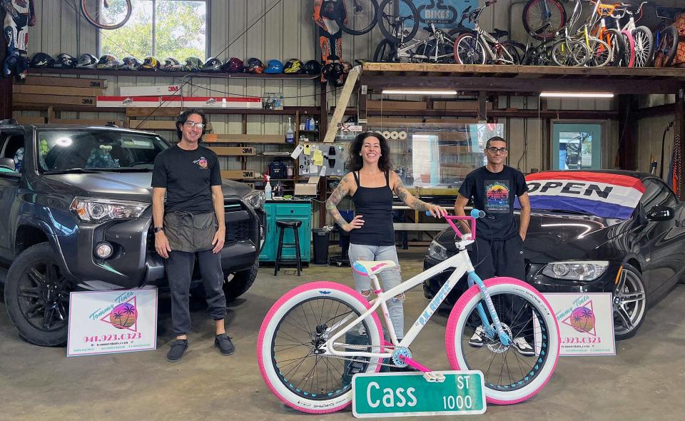 Cass St. Cycles owner Lauren Clark, Tommy Tint’s Pete Reali, left, and Jay Perez, who specializes in detailing, paint correction and lighting, at the Sarasota business they share.