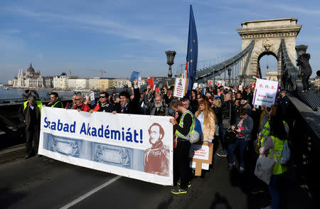 FILE PHOTO: People take part in a protest against government's plans to overhaul the Hungarian Academy of Sciences, on the Chain Bridge in Budapest, Hungary, March 21, 2019. The banner reads "Free academy". REUTERS/Tamas Kaszas/File Photo