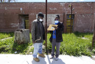 Kenneth West, left, talks with registered nurse Precious McCormick about receiving a Moderna COVID-19 vaccine, in Detroit, Wednesday, May 12, 2021. In three weeks, more than 40 people have received vaccinations through the program to reach people who normally have little to no access to churches, community centers or other places where vaccines are being given. Mobile care teams consisting of two nurses and a peer support specialist accompany The Salvation Army's Bed & Bread trucks as they cruise Detroit, which lags far behind the state and nearby communities in percentage of people vaccinated. (AP Photo/Paul Sancya)