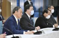 Japanese Prime Minister Yoshihide Suga, left, attends a cabinet meeting at his official residence in Tokyo Tuesday, April 12, 2021. Japan’s government said Tuesday it has decided to start releasing massive amounts of radioactive water stored at the wrecked Fukushima nuclear plant in two years after treatment. Suga told that the government adopted the release to sea as “most realistic” and that the disposal of the water is “unavoidable in order to achieve Fukushima's recovery.” (Yoshitaka Sugawara/Kyodo News via AP)