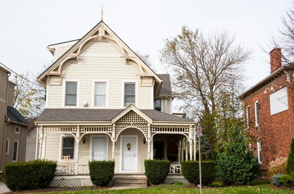 An older style white wooden house in the autumn season.