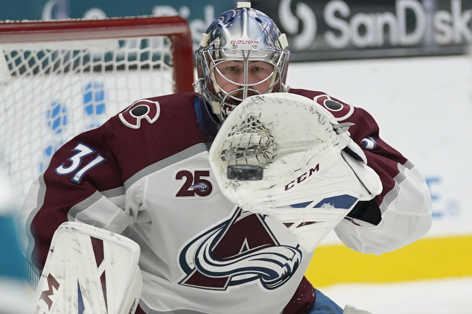 Colorado Avalanche goaltender Philipp Grubauer (31) catches a shot attempt by the San Jose Sharks during the second period of an NHL hockey game in San Jose, Calif., Monday, March 1, 2021. (AP Photo/Jeff Chiu)