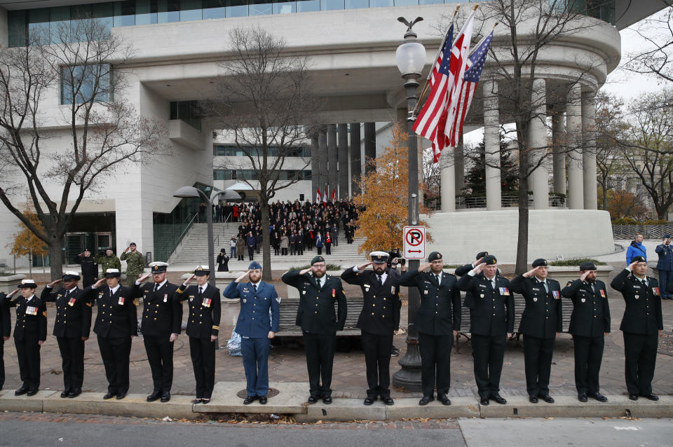 Canadian military salute on the sidewalk outside the Canadian Embassy, as the hearse carrying the flag-draped casket of former President George H.W. Bush drive by on Pennsylvania Ave. from the Capitol to a State Funeral at the Washington National Cathedral on December 5, 2018 in Washington, DC. (Photo: Alex Brandon – Pool/Getty Images)