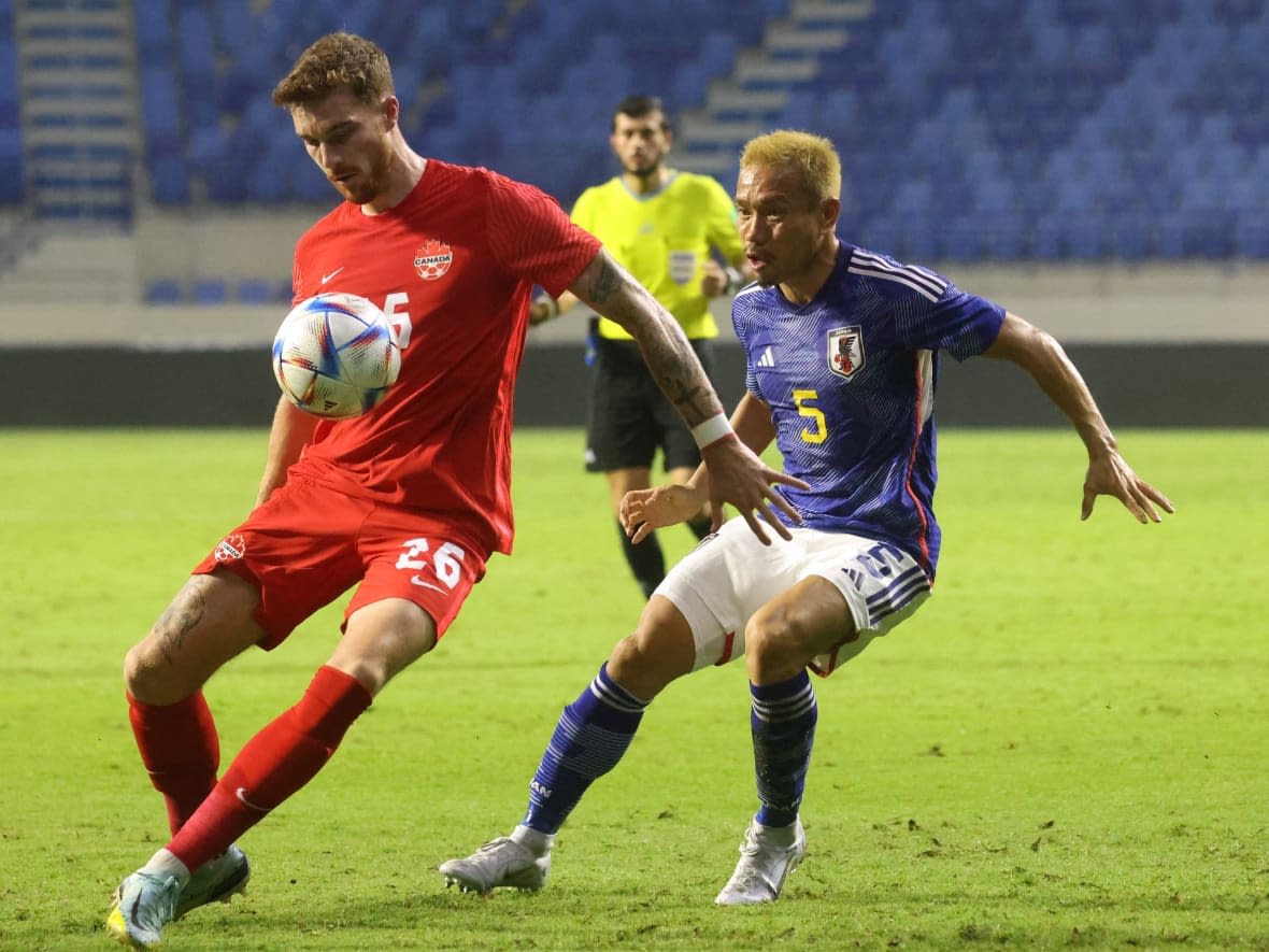 Canada's Joel Waterman, left, controls the ball while being marked by Japan's defender Yuto Nagatomo during a friendly football match between Canada and Japan at Al-Maktoum Stadium in Dubai on Nov. 17. (KARIM SAHIB/AFP via Getty Images - image credit)