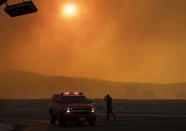 Police and firefighters are out in full force on Jeffrey and Portola in Irvine, Calif., where smoke fills the sky from the wind-driven Silverado wildfire on Monday, Oct. 26, 2020. (Mindy Schauer/The Orange County Register via AP)