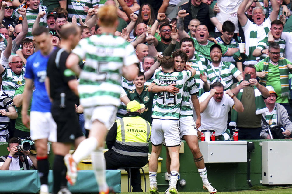 Celtic's Celtic's Matt O'Riley, right, celebrates with team-mate James Forrest after scoring his side's first goal during the Scottish Premiership soccer match between Glasgow Rangers and Celtic Glasgow, at the Celtic Park, in Glasgow, Scotland, Saturday May 11, 2024. (Jane Barlow/PA via AP)
