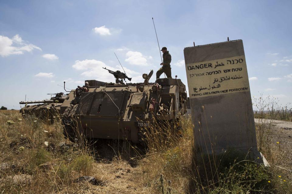 An Israeli soldier stands atop a tank near Alonei Habashan on the Israeli occupied Golan Heights, close to the ceasefire line between Israel and Syria, June 22, 2014. (REUTERS/Baz Ratner)