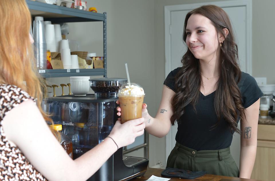 Beans and Bookmarks is a new family-owned coffee shop/bookstore located on Reidville Road in Spartanburg. Callie Yarbrough is the owner of this family-owned and run business. Many of the  customers are also family friends that stop off to have a chat with Callie. Here, Callie says hello to a friend as she fills her order. 
