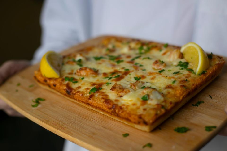 Todd Stern, owner of Detroit Pizza Joint in Cape Coral, displays one of his signature offerings, the garlic shrimp pizza with fresh lemon.