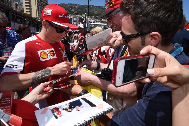 Ferrari's Finnish driver Kimi Raikkonen signs autographs in the pit line area of the Monaco Formula One Grand Prix in Monte Carlo on May 22, 2015