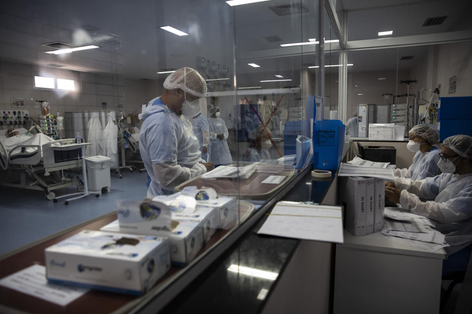 Health workers stand in a COVID-19 intensive care unit at the Dr. Ernesto Che Guevara hospital in Marica, Brazil, Wednesday, Jan. 26, 2022. (AP Photo/Bruna Prado)