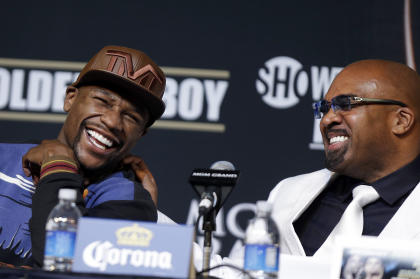 Floyd Mayweather Jr. (L) and Mayweather Promotions CEO Leonard Ellerbe, laugh during a press conference. (AP)