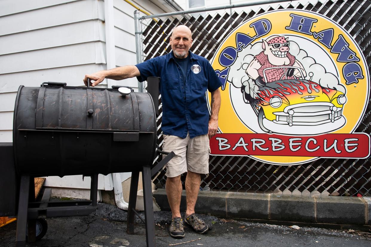 Road Hawg Barbecue owner Keith Walters poses for a photo next to his original smoker on April 12, 2024.