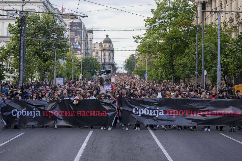 People hold banners with writing reading: "Serbia against violence" during a march against violence in Belgrade, Serbia, Friday, May 12, 2023. Serbia’s populist leader has sharply denounced opposition plans to block a key bridge and highway in Belgrade on Friday to press their demands in the wake of last week’s mass shootings in the Balkan country that left 17 people dead, including many children. (AP Photo/Darko Vojinovic)