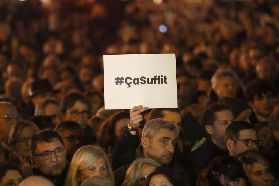 People gather at the Republique square to protest against anti-Semitism, in Paris, France, Tuesday, Feb. 19, 2019. Poster reads : that's enough. In Paris and dozens of other French cities, ordinary citizens and officials across the political spectrum geared up Tuesday to march and rally against anti-Semitism, following a series of anti-Semitic acts that shocked the nation. (AP Photo/Christophe Ena)