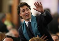 Canada's Liberal Leader Justin Trudeau waves to a fellow guest as he takes his seat at the state funeral for Canada's former finance minister Jim Flaherty in Toronto, April 16, 2014.